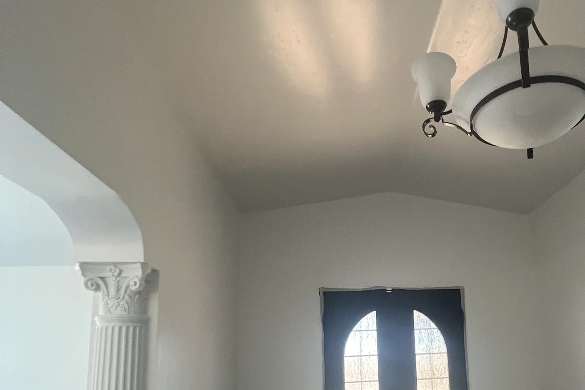 Entryway with a column, arched doorway and chandelier freshly painted, a Tony's Painting interior job in San Diego County